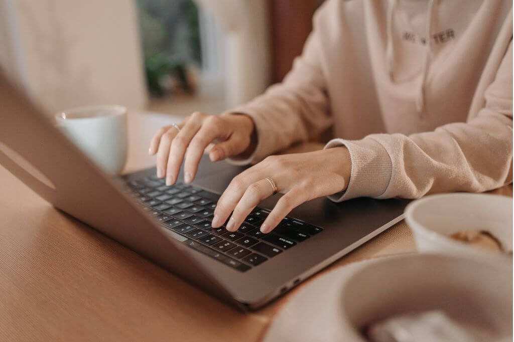 Woman's hands typing on laptop