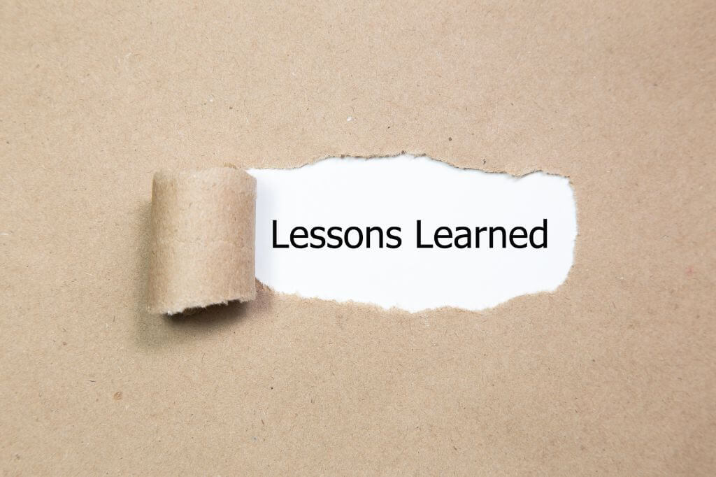 Brown paper torn to reveal the words "lessons learned" underneath