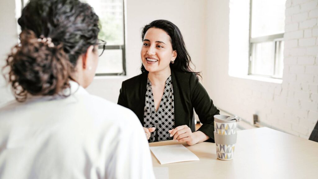 Woman giving another woman advice in a business setting